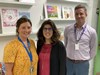 Jill Unger, Ryan Zak and Dr. Laura Ascenzi Moreno pose near a stack of books.